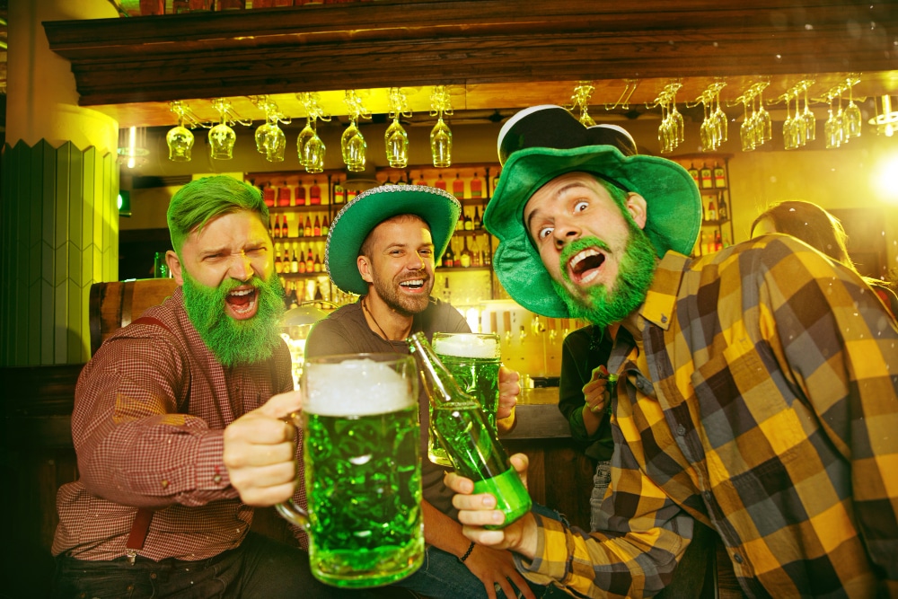 saint-patrick-s-day-party-happy-friends-are-celebrating-and-drinking-green-beer-young-men-and-women-wearing-green-hats-pub-interior